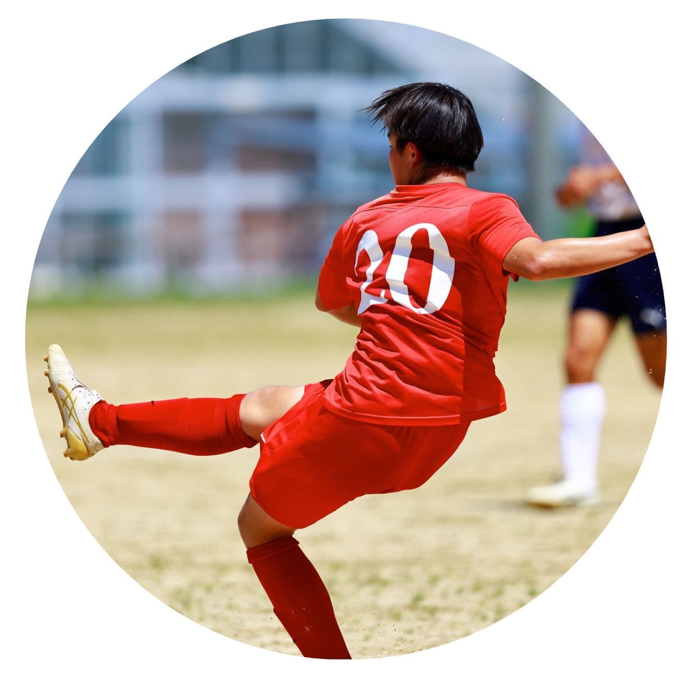 サッカーをしている赤いユニフォームを着た男性